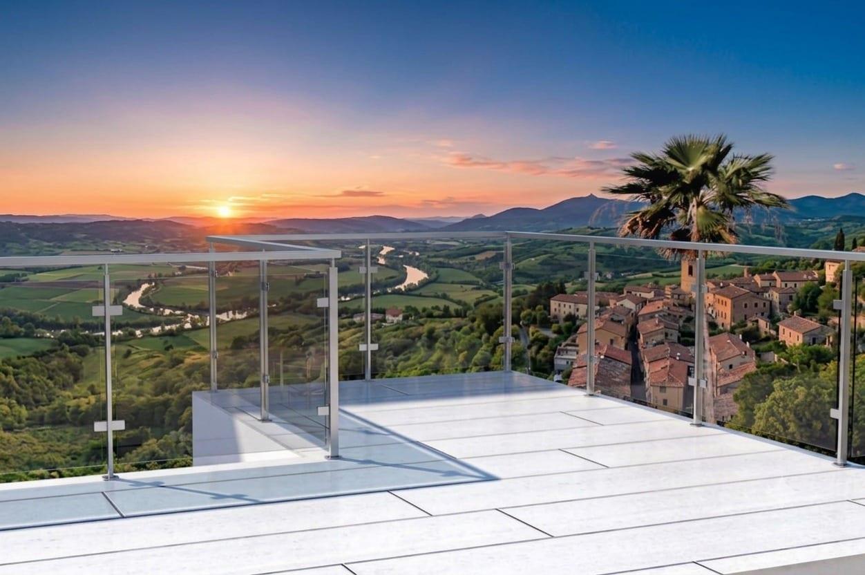 A glass balustrade along a terrace looking over the valley at sunset.